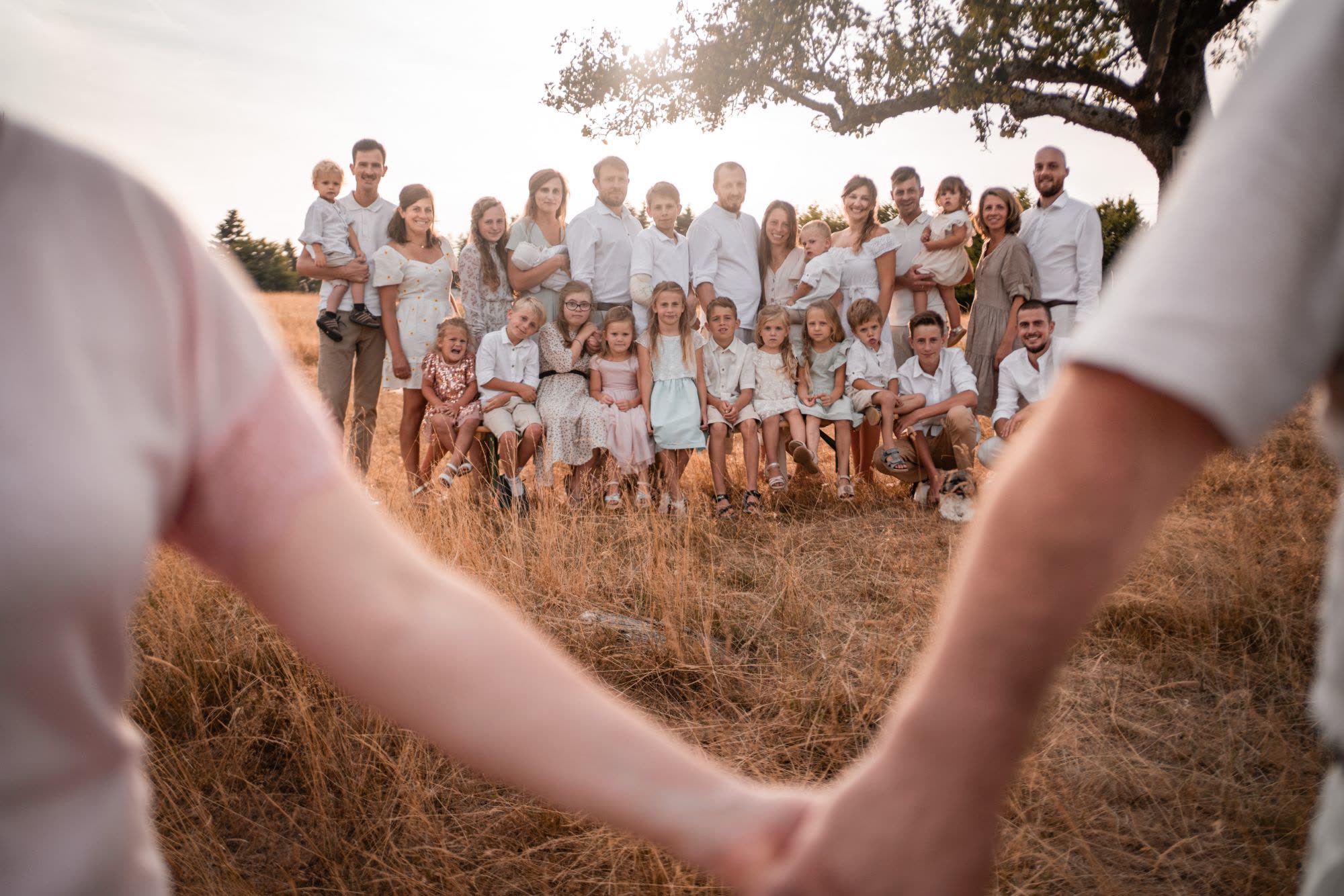 Großfamilie im Feld unter einem Baum